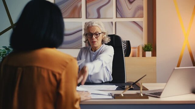 Annoyed woman boss scolding female employee for failed project, workplace stress