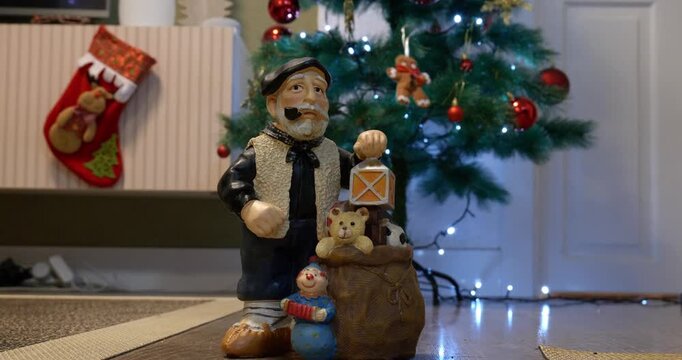 Close-up of the Christmas figure &lsquo;Olentzero&rsquo;. A girl turns on the Christmas tree lights. 
