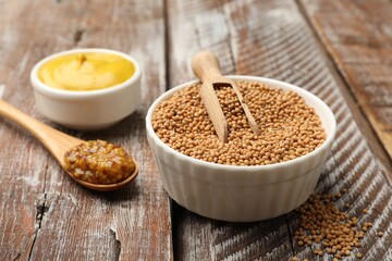 Different types of mustard on wooden table, closeup