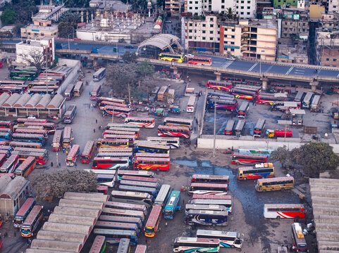 Aerial view of a vibrant tapestry of buses parked tightly together at Sayedabad Bus Terminal, creating a mosaic of colors against the cityscape, Dhaka, Dhaka Division, Bangladesh.