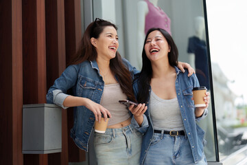 Naklejka premium Joyful Connection. Two young women laughing and enjoying coffee together.
