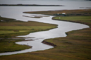 Iceland - Serene Aerial View of a Winding River Through Lush Green Fields Flowing into a Distant Lake