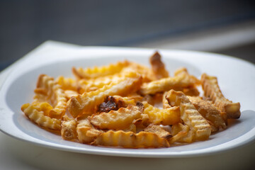 Crispy Golden Crinkle Cut French Fries Served on a White Plate, Ready to Be Enjoyed as a Snack or Side Dish