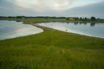 Tranquil Rural Scene with Lakes and a Dividing Land Bridge Leading to Distant Homes