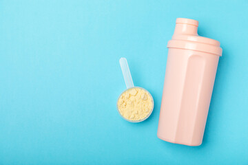 Protein shake with protein powder on a colored background. The powder is mixed with water or milk....
