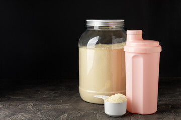 Protein shake with protein powder on a colored background. The powder is mixed with water or milk. A dietary supplement for a balanced diet. Whey protein. Fitness and gym diet nutrition.