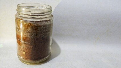 Close up of  coffee powder texture in the bottle. Ground or instant powdered coffee isolated on white background. Top view, clipping. Coffee grounds inside an old reused bottle with dull edges.
