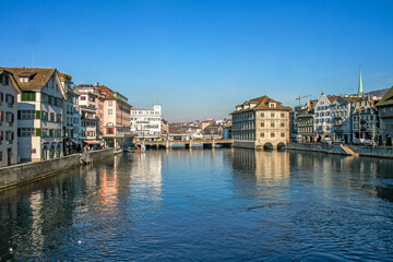 Obraz premium A picturesque view of central Zurich, featuring historic architecture and the river's reflection on a sunny day. A tourist destination in Switzerland.
