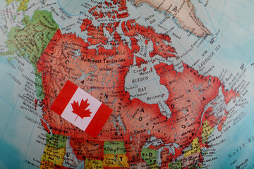 Naklejka premium Miniature national flag of Canada on world map