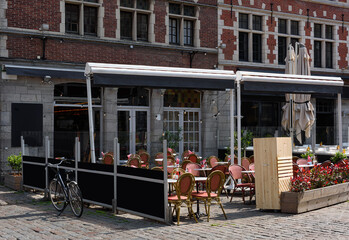 Old street with tables of cafe in Ghent (Gent), Belgium. Architecture and landmark of Ghent. Cozy cityscape of Ghent.