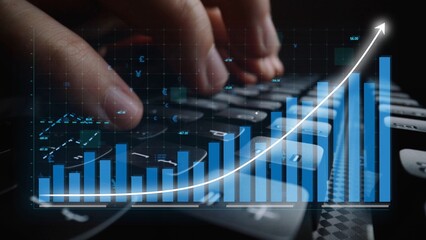 Close-up of hands typing on a computer keyboard with a digital graph overlay, symbolizing growth and analysis in technology and finance. Copula