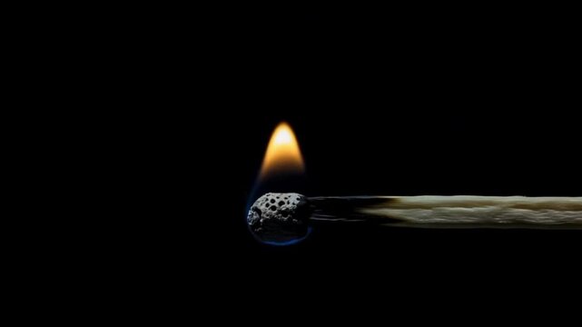 Ignited match flares vibrantly against deep darkness, symbolizing new beginnings, inspiration, or a crucial moment sparking into action.