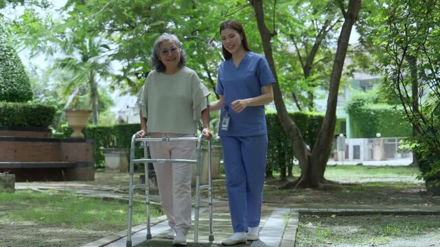 The caregiver is helping an elderly Asian woman rehabilitate her walking and monitor her condition after she underwent knee surgery, using treatment information from her doctor.