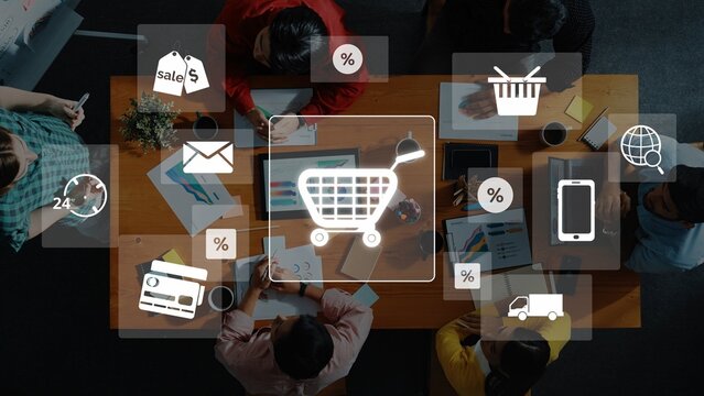 Dynamic overhead view of a diverse team collaborating on e-commerce strategies, illustrated with digital icons symbolizing online shopping and market analytics. Raster