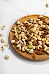 Nuts assortment on wooden plate close up food