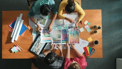 Top down aerial view of interior designer team choosing color from palettes while architect...