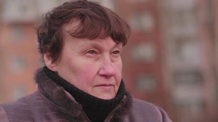 Elderly woman reflecting thoughtfully in urban park during a cool afternoon in early autumn - Powered by Adobe
