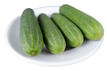 Fresh cucumbers sitting on white plate, looking vibrant and healthy, feast for eyes
