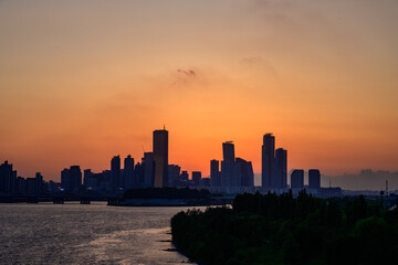 Fototapeta premium The night view of the city of Yeouido, a high-rise building, shot at Dongjak Bridge in Seoul at sunset