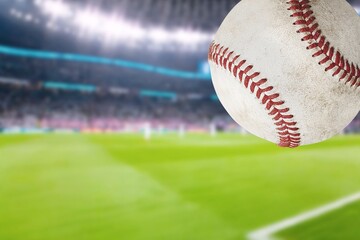 Baseball Flying  ball with green Stadium in the Background.