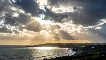 Dramatic coastal sunset with sunbeams through clouds