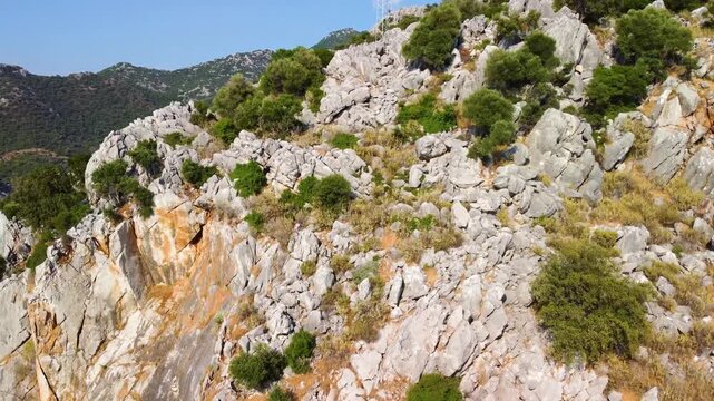 Drone footage capturing the natural beauty of Cennet Koyu Paradise Bay in Turkey, featuring rugged mountains, lush green vegetation, and the serene Mediterranean coastline.