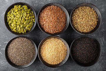 Pumpkin, sesame, flax, hemp, chia seeds in bowls, seeds for good health of mind and body, enriched with minerals and vitamins. Top view