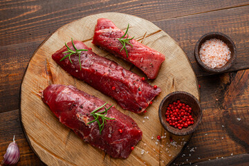Raw beef steak. Raw fresh farm steak on cutting board on wooden background. Raw beef steak for cooking.