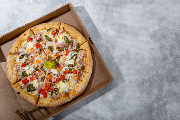 Mexican pizza with meat and jalapeno in a box, top view, copy space for text