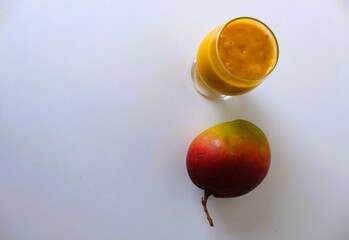 Healthy vegan cold drink with organic mango. With a white background and copy space.