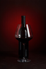 Wine Bottle and Empty Glass on Red and Black Gradient Background