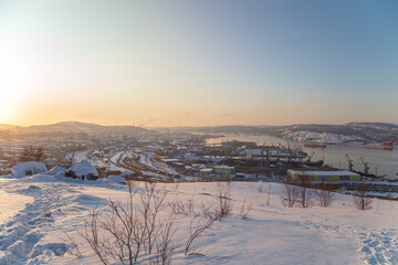 View of the Murmansk seaport from the Green Cape hill. Low sun during the polar night.