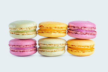 Stack of colorful French macarons isolated on light background.