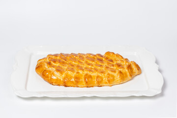 Golden fish-shaped pie on white plate, Perfect for menus, food photography, and advertising