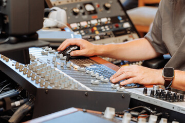 Fototapeta premium Close-up Hands of a sound engineer on mixing console.