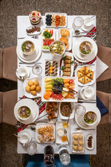 Top view of a lavish table with soups, fruits, sweets, and appetizers on White Background