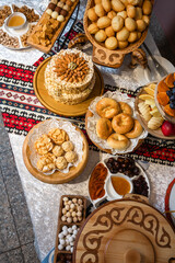 Top view of table with baklava, nut cakes, buns, and fruits.