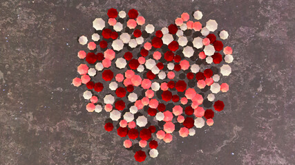A multitude of red and white umbrellas form the shape of a heart.