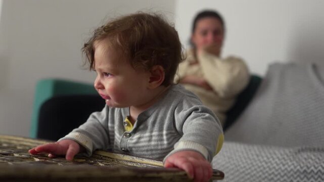 Baby leaning on table coughing with red eyes after slight choking incident, authentic parenting moment showing vulnerability, care, and everyday challenges of childhood at home