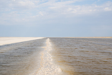 Landscape of a salt lake with a flat white surface under the light of a blue sky. Lake Baskunchak...