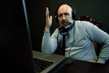 Middle-Aged Podcaster Speaking Into Microphone While Recording at Home