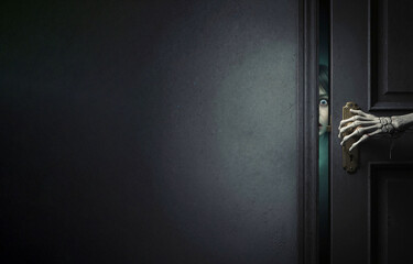Skeleton hand on doorknob with scared child in doorway (copy space)
