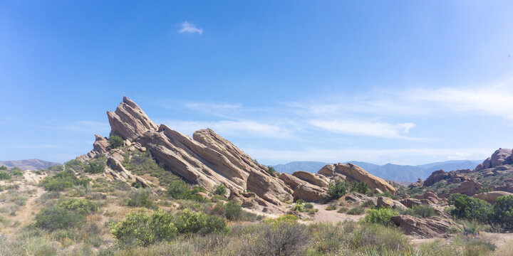 A lifeguard station on a beach with people enjoying the sunset on a partly cloudy day at the ocean