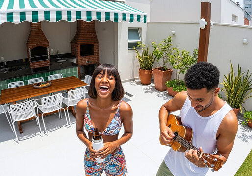 Joyful couple celebrating summer vibes with music and drinks on a sunny rooftop patio featuring a barbecue area