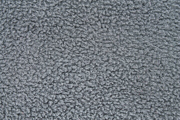 Gray fleece texture background. Macro of a soft sherpa or terry cloth material. Concept of winter warmth, comfort, and coziness.