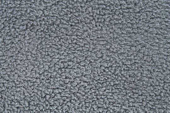 Gray fleece texture background. Macro of a soft sherpa or terry cloth material. Concept of winter warmth, comfort, and coziness.