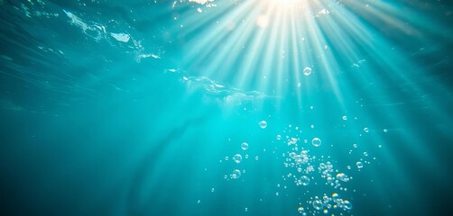 Sunbeams pierce turquoise water, illuminating playful bubbles,  beauty,  stock photo