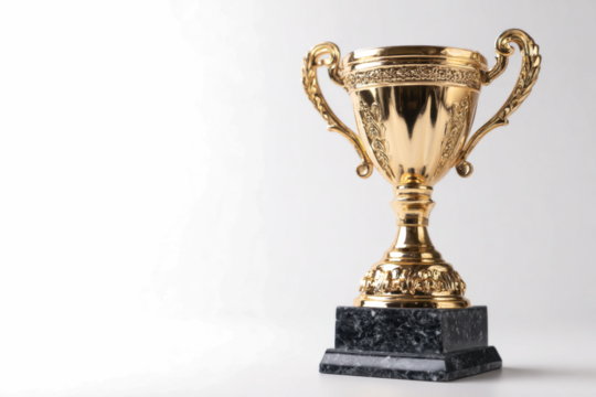 A gleaming gold trophy cup with ornate handles stands on a dark marble base against a clean white background.