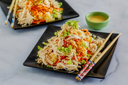 deconstructed egg roll with shredded chicken, carrot, and cabbage . . . topped with green onion