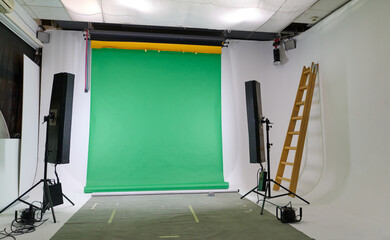 Naklejka premium Modern empty green photo or video studio with green chroma key backdrop and strobe flash lights. 